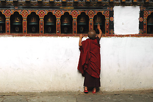 Jonge monnik, draaiend aan een gebedswiel (Paro Rinpung Dzong)